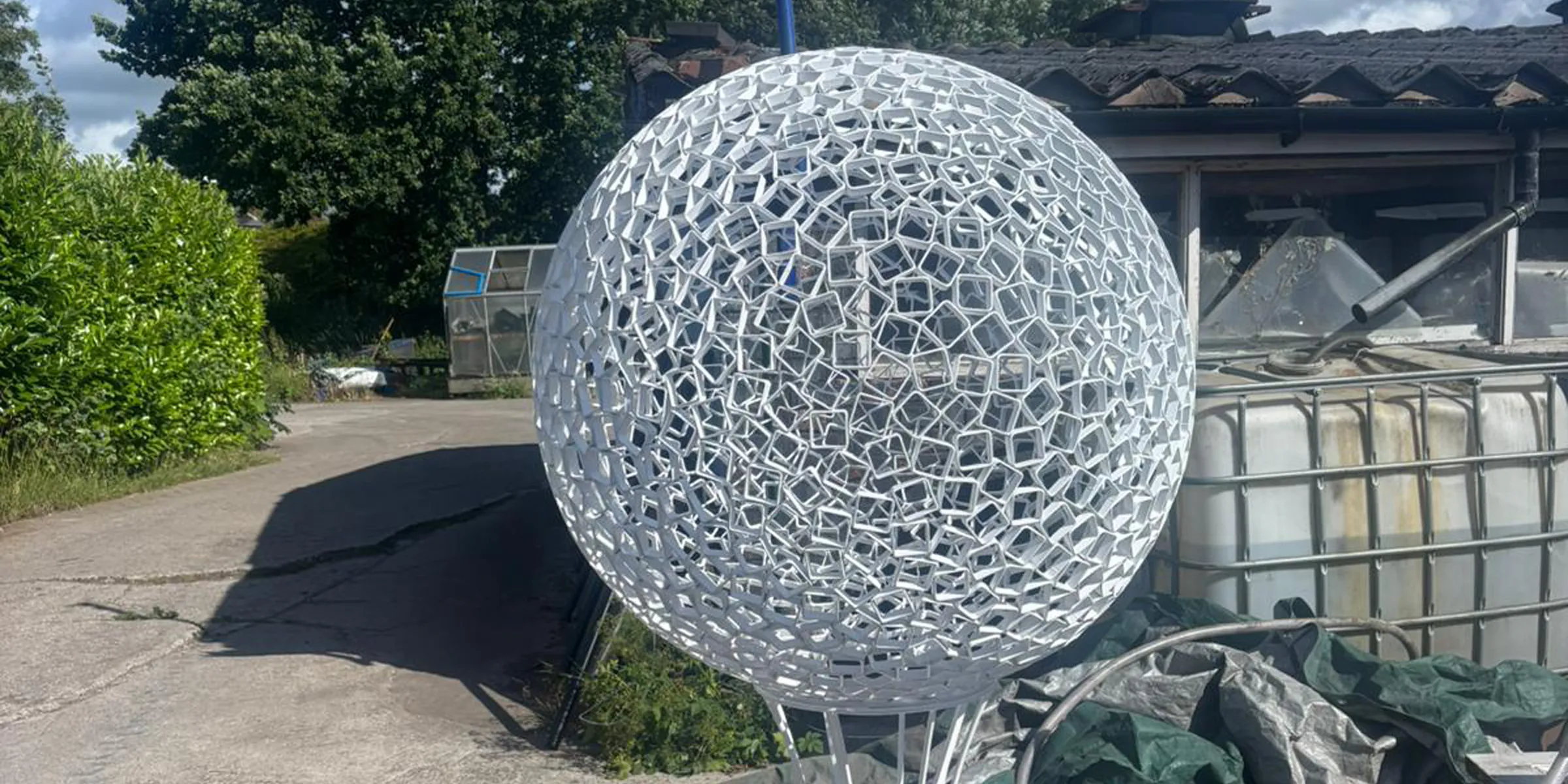 Life of the Northwest — the hand-welded steel sphere sculpture on its tapered stem.